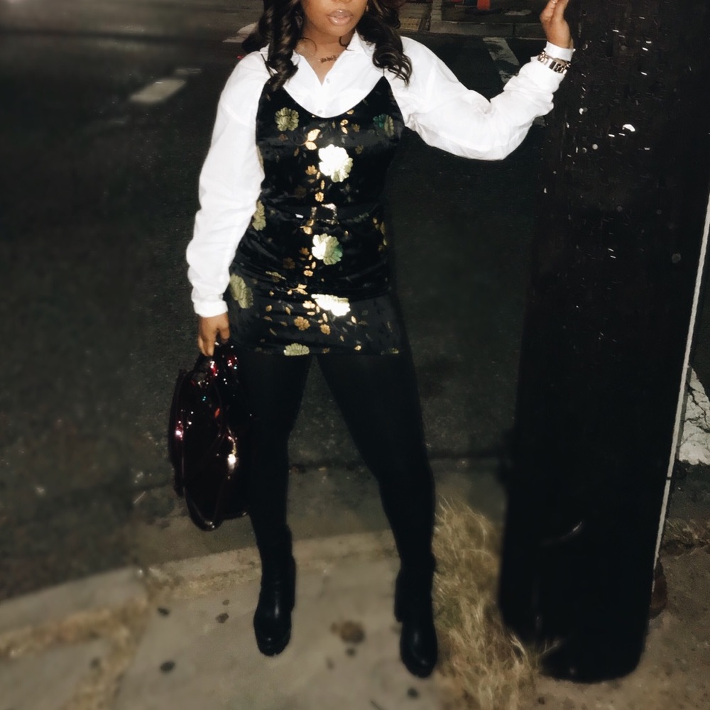 Black dress embellished with gold/green flowers.